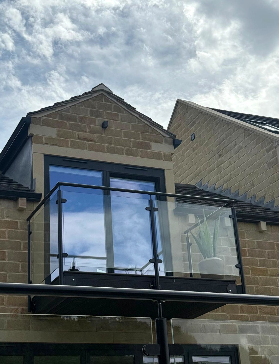 Side-fixed powder-coated steel and glass balcony balustrade on a stone house, Sheffield